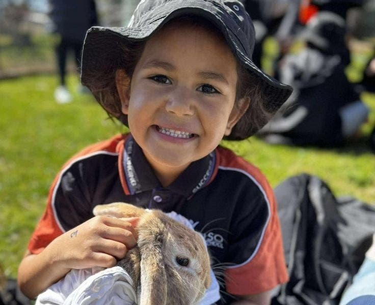 A photo of a student holding a rabbit.